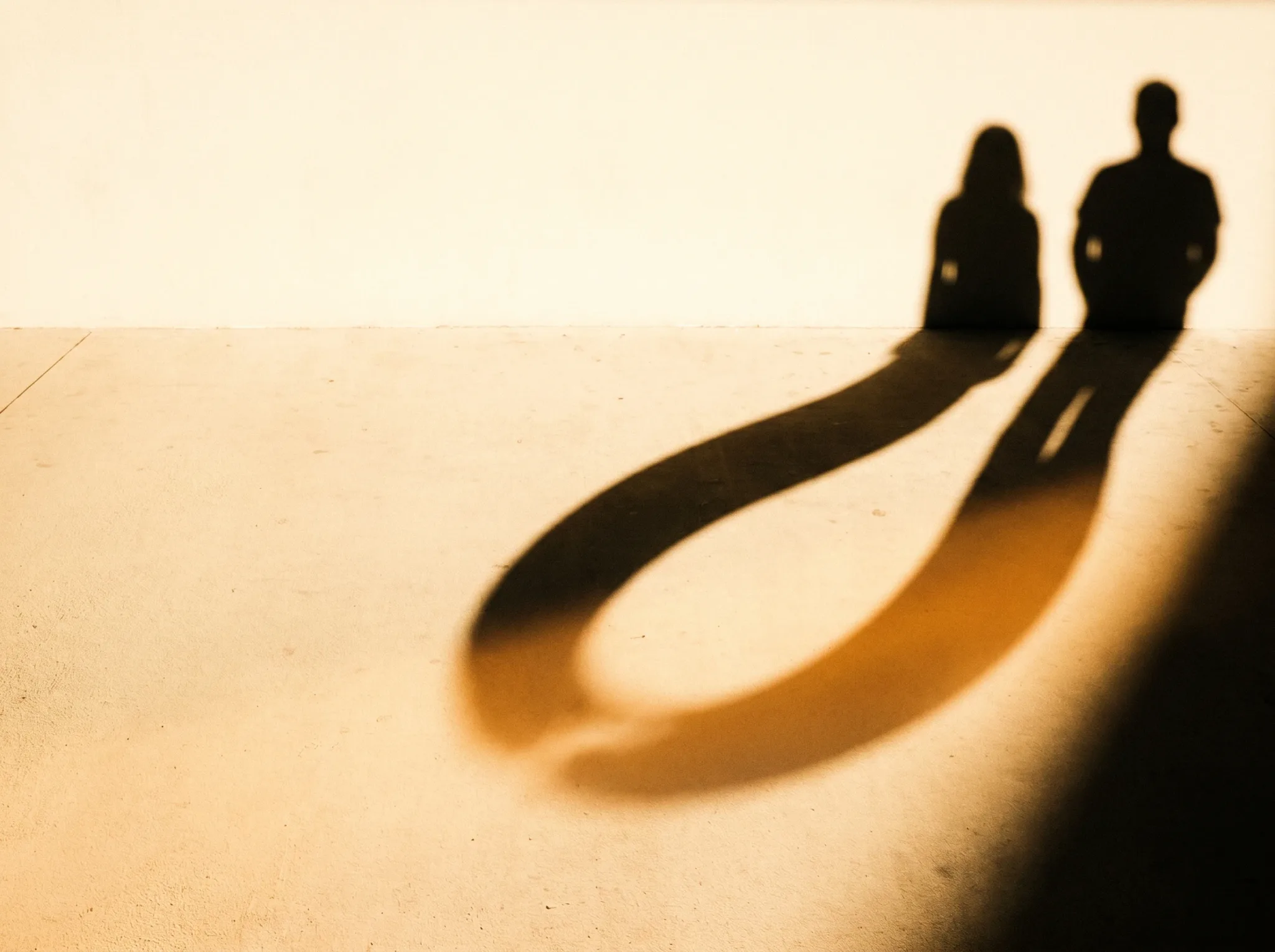 Zwei Silhouetten, deren Schatten sich zu einer durchgehenden Schleife verbinden — der Beziehungszyklus wird sichtbar.